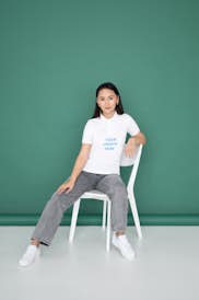 Asian woman wearing a polo T-shirt sitting on the chair