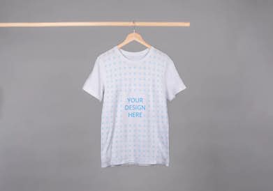T-shirt on the wooden hanger in front of the gray background