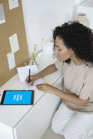 African-American woman using iPad Pro on the white cabinet