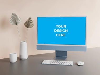 Blue iMac on the grey table with decorative flowers