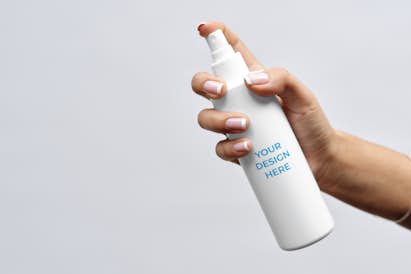 Cosmetic spray bottle in the hand of a woman