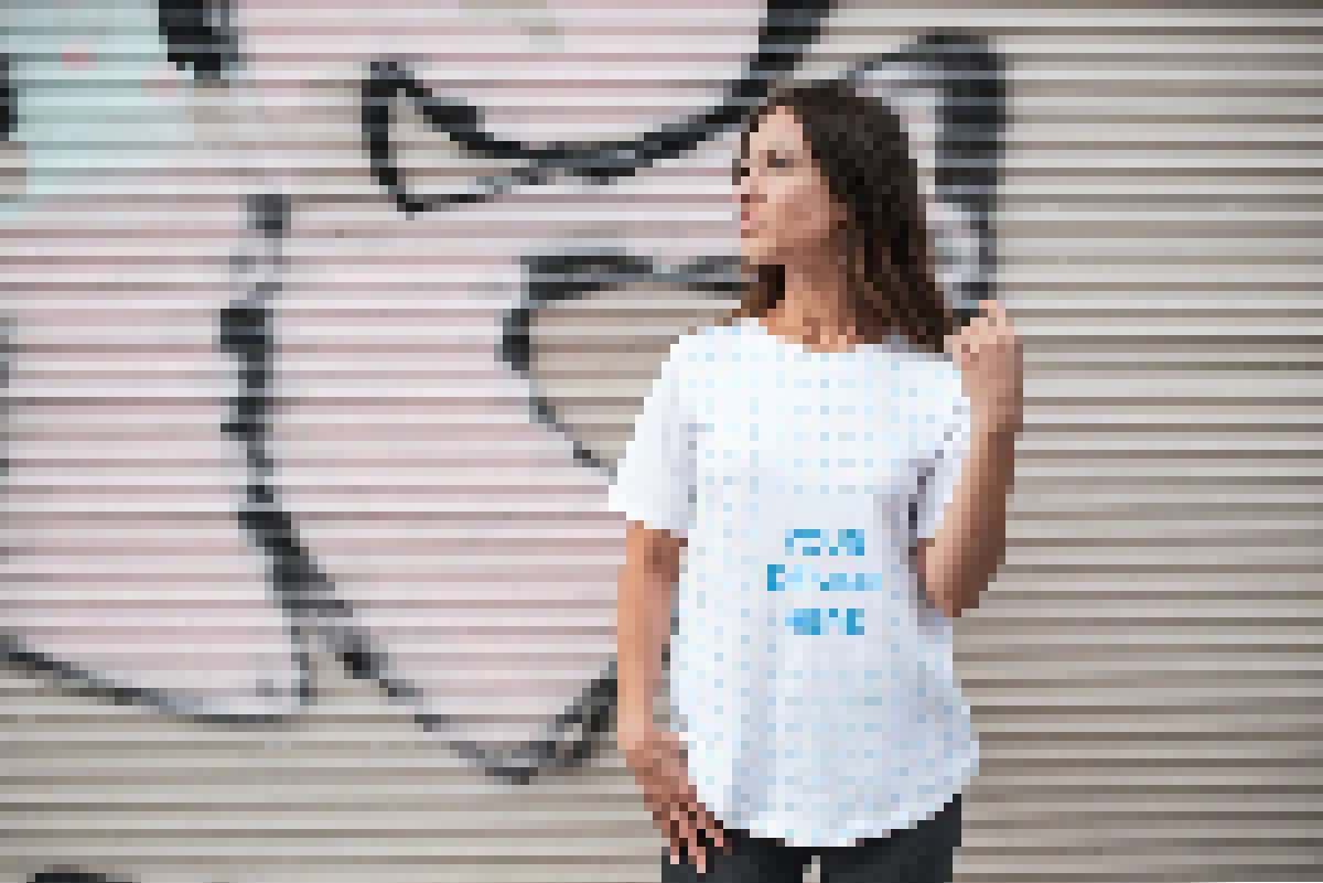 Brunette woman wearing a T-shirt near the wall